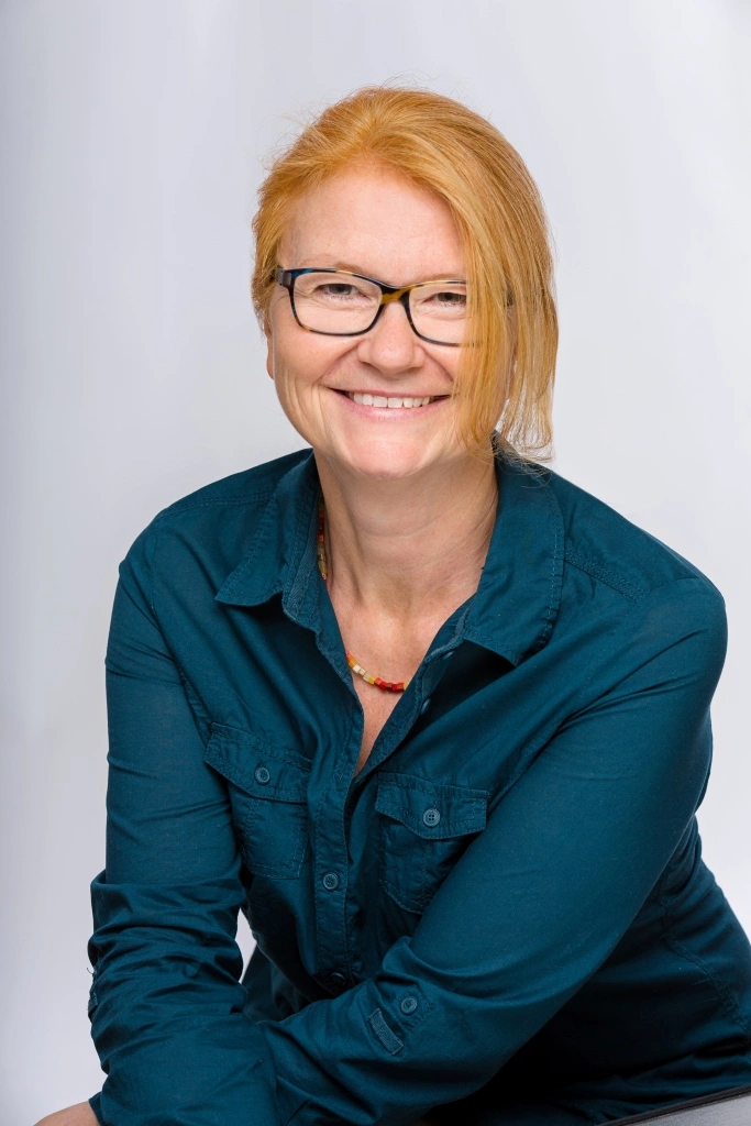 Maria Richter von Mindful-Business Portraitfoto, sie lächelt in die Kamera, die Haare sind zu einem Zopf zugebunden
